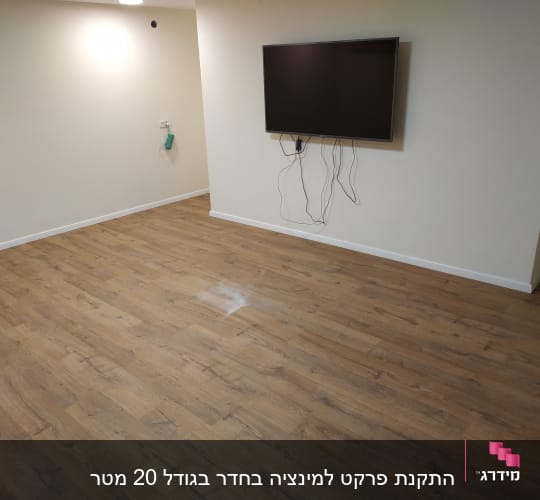 רצפת פרקט עץ בחדר עם קירות לבנים